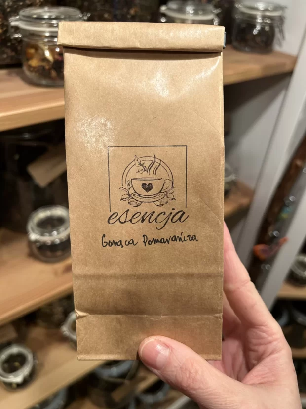 Susz Gorąca Pomarańcza w opakowaniu papierowym 50 gram trzymany w ręce