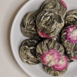 Kule herbaty Kwiat Lychee na talerzyku.