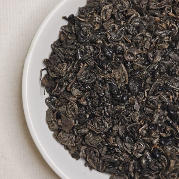 Liście Gunpowder Black na talerzyku.