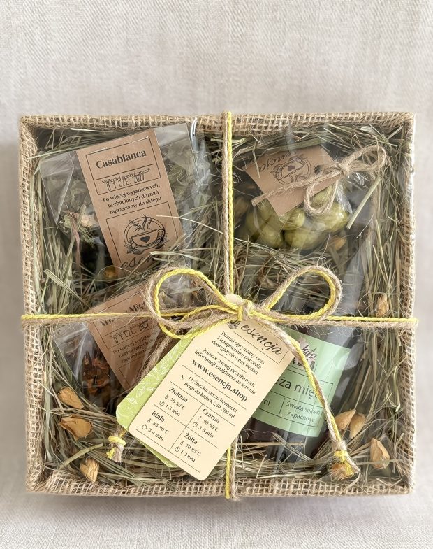 Pudełko prezentowe, a środku świeca sojowa miętowa, dwie herbaty i delikatesy.