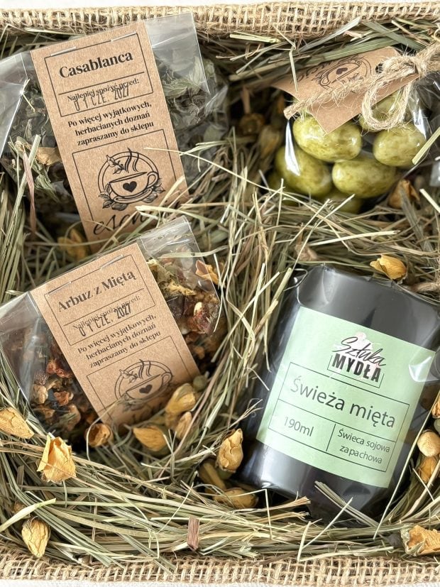 Zbliżenie na zestaw prezentowy - miętowa świeca, herbaty i migdały z czekoladzie z matchą.