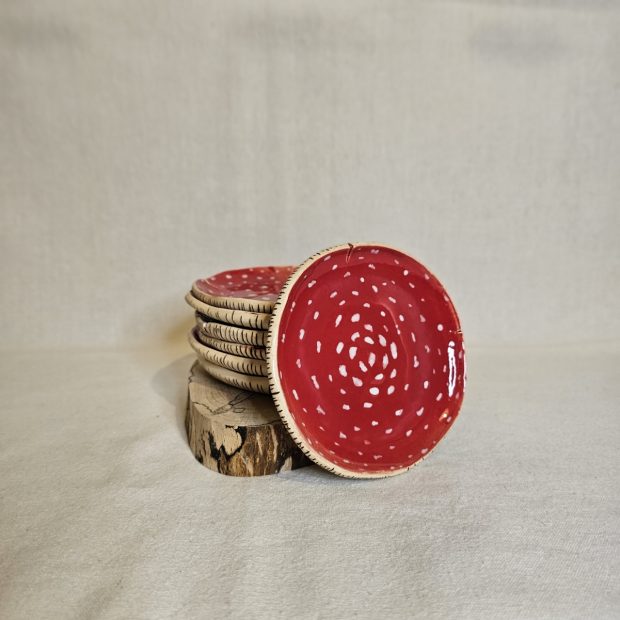 Spodki przypominające kształtem i kolorem muchomorka ułożone w stosik.